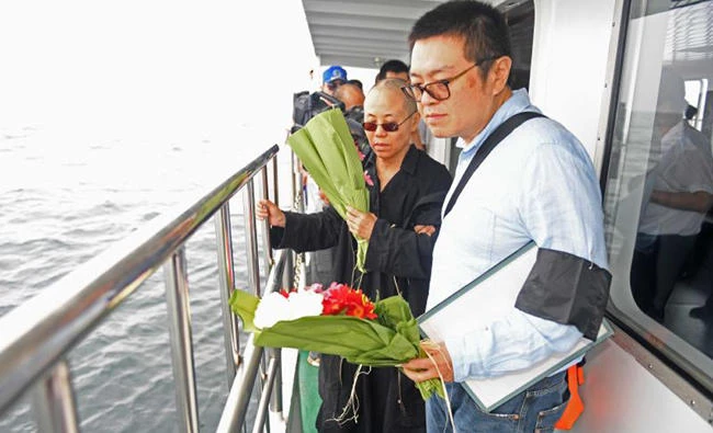 Liu Xia, left, the wife of deceased Chinese Nobel laureate Liu Xiaobo, and her younger brother Liu Xiaoxuan, right, bury Liu’s ashes at sea off the coast of Dalian in northeastern China’s Liaoning Province, Saturday. (AP)