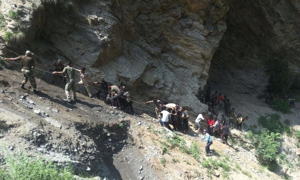 Indian police and locals carry injured people from the site of a bus crash. (AFP)