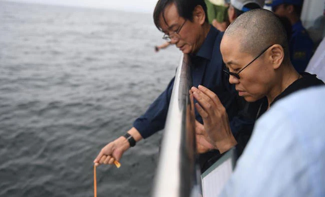 Late Nobel laureate Liu Xiaobo's wife Liu Xia praying as they bury Liu's ashes at sea off the coast of Dalian, Liaoning Province, on July 15, 2017. (AFP)