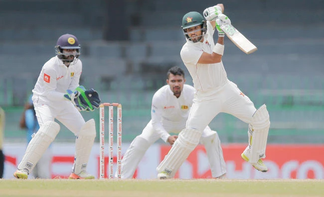 Sikandar Raza of Zimbabwe plays a shot as Sri Lankan wicket keeper Niroshan Dickwella, left, watches during the third day’s play of the one-off Test cricket match between Sri Lanka and Zimbabwe in Colombo Sunday. (AP)