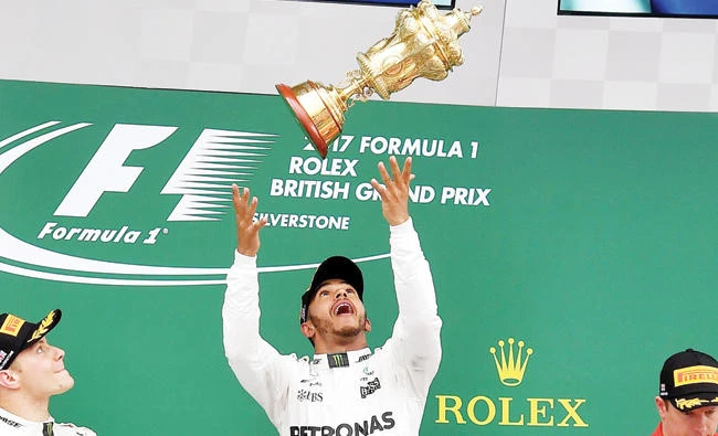 Winner Mercedes’ British driver Lewis Hamilton, center, celebrates with his trophy next to second placed Mercedes’ Finnish driver Valtteri Bottas, left, and third placed Ferrari’s Finnish driver Kimi Raikkonen after the British Formula One Grand Prix on Sunday. (AFP)