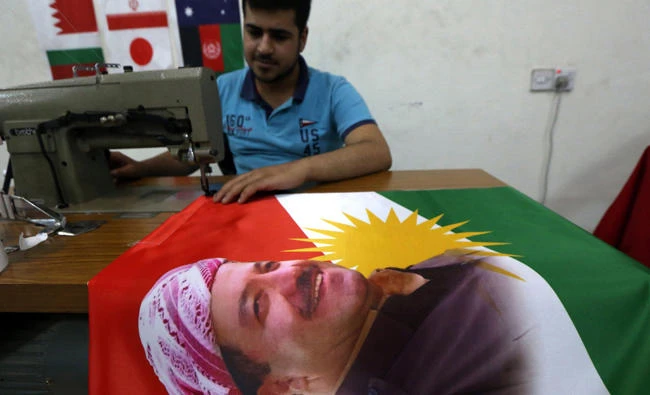 An Iraqi man sews a flag of Kurdistan bearing the portrait of Iraqi Kurdish leader Massud Barzani, in Arbil, the capital of the autonomous Kurdish region of northern Iraq. Iraq's autonomous Kurdish region will hold a historic referendum on statehood in September, despite opposition to independence from Baghdad and possibly beyond. (AFP file photo)