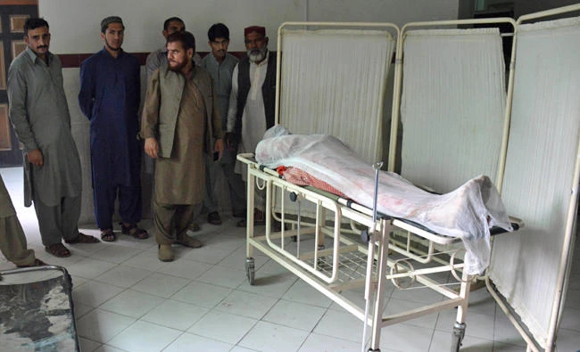 Pakistani Kashmiris gather around the body of an army soldier on a trolley in Athmaqam on Sunday, after his death in a cross-border firing incident in Pakistan-administered Kashmir's Neelum Valley. (AFP)