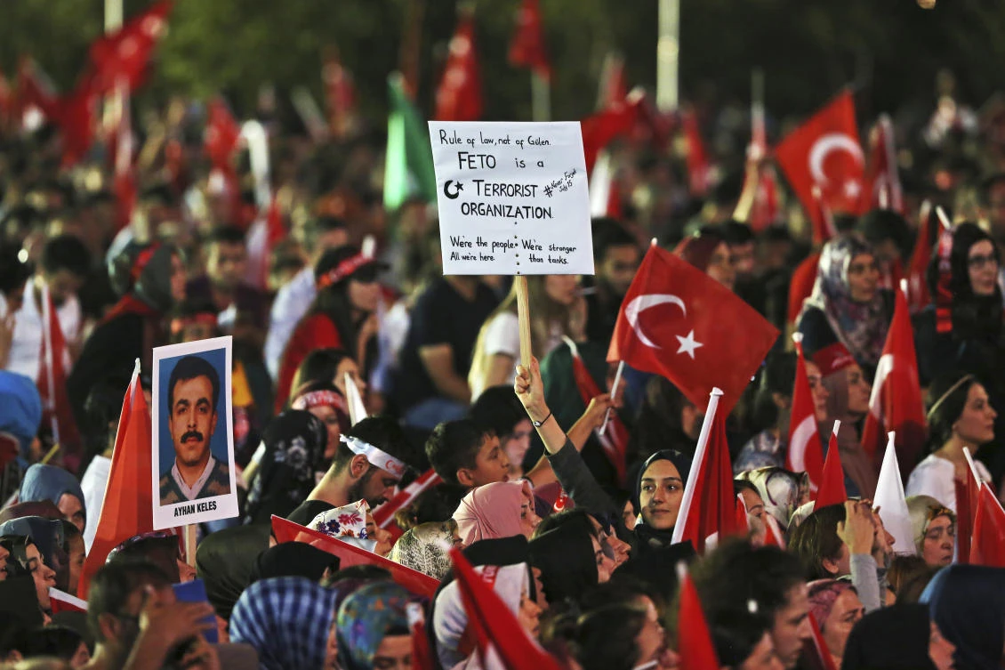 People participate in a ceremony to commemorate the one year anniversary of the July 15, 2016 failed coup attempt, at Turkey's Parliament in Ankara, Turkey, early Sunday, July 16, 2017. Turkey commemorates the first anniversary of the July 15 failed military attempt to overthrow Turkey's President Recep Tayyip Erdogan, with a series of events honouring some 250 people, who were killed across Turkey while trying to oppose coup-plotters. "FETO" on the banner is the name that Turkish government uses to describe the organization of U.S.-based cleric Fethullah Gulen, who is accused of orchestrating the coup.(AP)