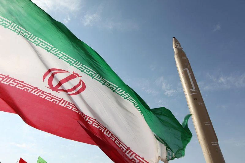 An Iranian flag flies near a surface-to-surface missile in an undisclosed location (AFP)