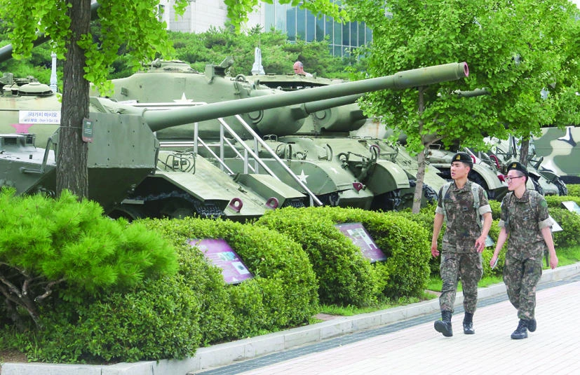 South Korean army soldiers pass by military vehicles deployed in the Korean War era at Korea War Memorial Museum in Seoul, Monday. (AP)