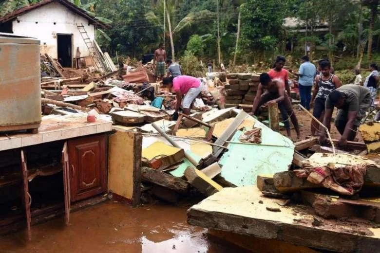 Sri Lankan residents clear debris from damaged homes following flooding in Yatagampitiya village in Bulathsinhala on June 2, 2017. (AFP)