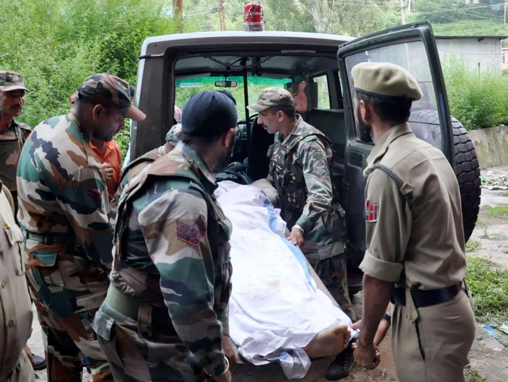 Indian army personnel and policemen move the body of a soldier reportedly killed along the line of control between India and Pakistan, to a morgue in the Bhimber Gali sector of the district of Rajouri, some 159kms from Jammu on July 17, 2017. (AFP)
