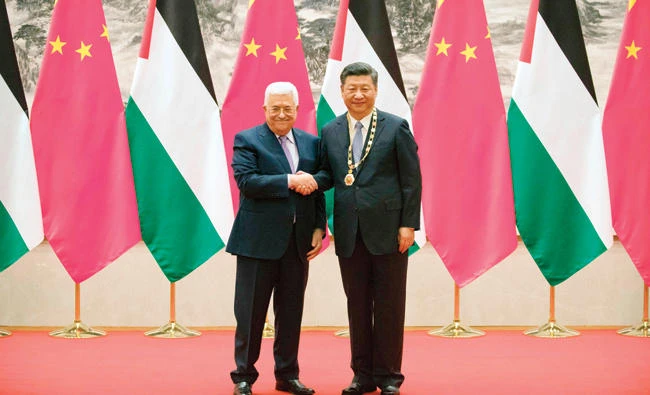 Palestinian President Mahmoud Abbas, left, and Chinese President Xi Jinping shake hands during a signing ceremony at the Great Hall of the People in Beijing on Tuesday. (AFP)