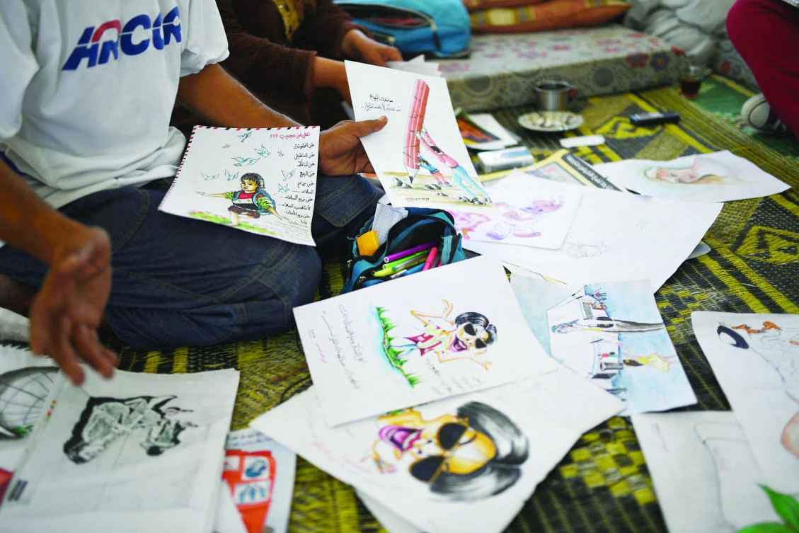 Syrian farmer Faysal shows his paintings at the Ain Issa camp in northern Syria on recently. (AFP)
