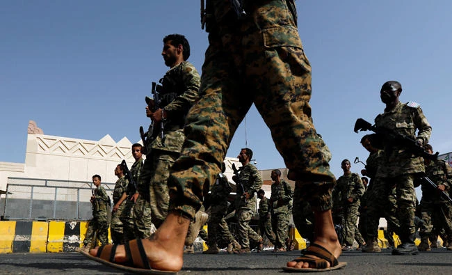 Newly recruited fighters parade outside the US embassy in Sanaa on Monday before joining Houthi insurgents in the frontline at the border with Saudi Arabia and in other parts of Yemen. (Reuters)