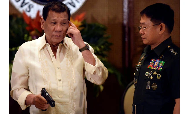 Philippine President Rodrigo Duterte holds a .45-caliber pistol while Gen. Eduardo Ano, chief of the Armed Forces of the Philippines, looks on during a turnover ceremony for procured firearms for the military at the Malacanang presidential palace in Manila on Tuesday. (Reuters)