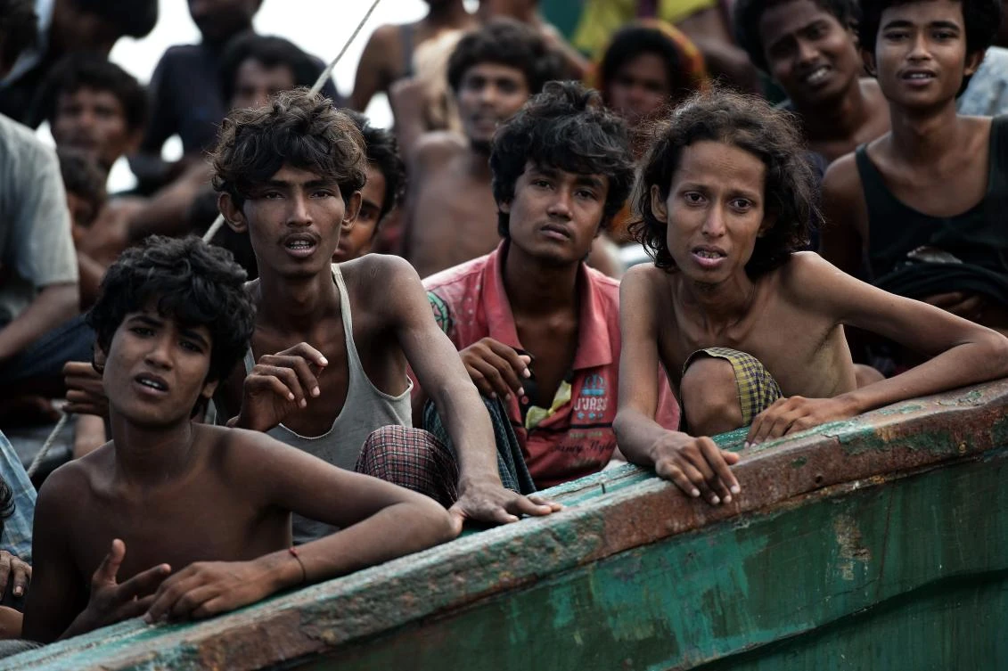 (FILES) This file photo taken on May 14, 2015 shows Rohingya migrants sitting in a boat drifting in Thai waters off the southern island of Koh Lipe in the Andaman Sea. A general is among more than 100 defendants awaiting a verdict on July 19, 2017 at Thailand's largest ever human trafficking trial, accused of running a brutal trade that left desperate Rohingya and Bangladehsi migrants stranded on boats and in jungle death camps. Tens of thousands of migrants were crammed over the years onto often barely sea worthy vessels to be ferried across the Andaman Sea to southern Thailand. (AFP)