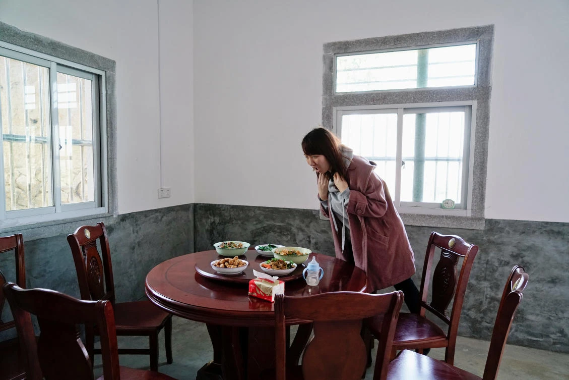 Wang Quanming (not pictured) takes a photograph of Zhao Yuqing at the table where she would have her first meal in Wang's family home, in Anxi, Fujian province, China, January 27, 2017. (REUTERS)