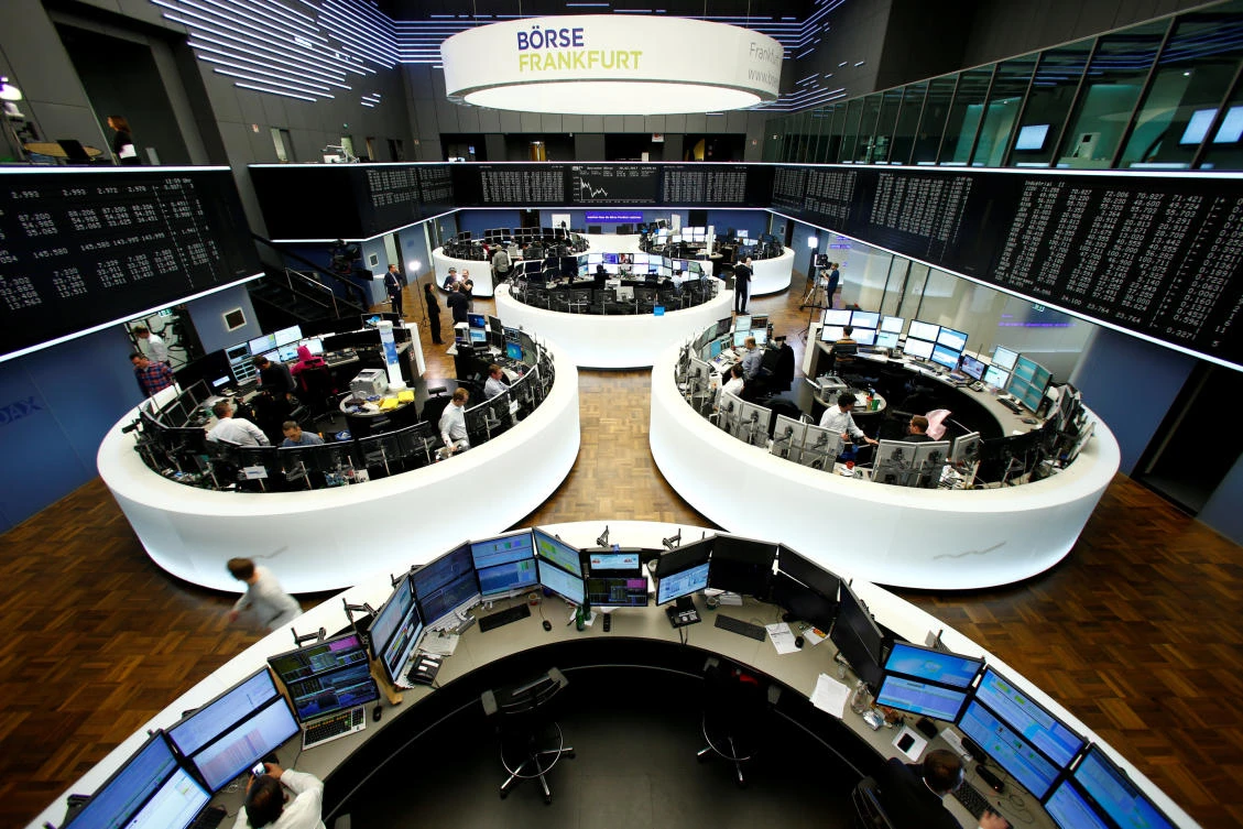Traders work at their desks at the stock exchange in Frankfurt. (Reuters)