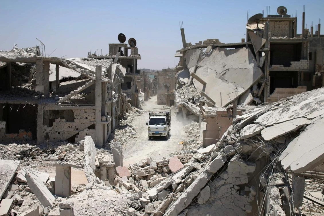 A teuck drives down a destroyed street in a rebel-held area in Daraa on July 19, 2017, as civilians started to return to the area following the July 9 agreement ceasefire brokered by the United States, Russia and Jordan creating a de-escalation zone in Syria's southern Daraa, Quneitra and Sweida regions. / AFP / Mohamad ABAZEED