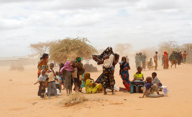 Newly arrived Somali refugees wait outside a UNHCR processing center at the Ifo refugee camp outside Dadaab, eastern Kenya, 100 km from the Somali border. (AP)