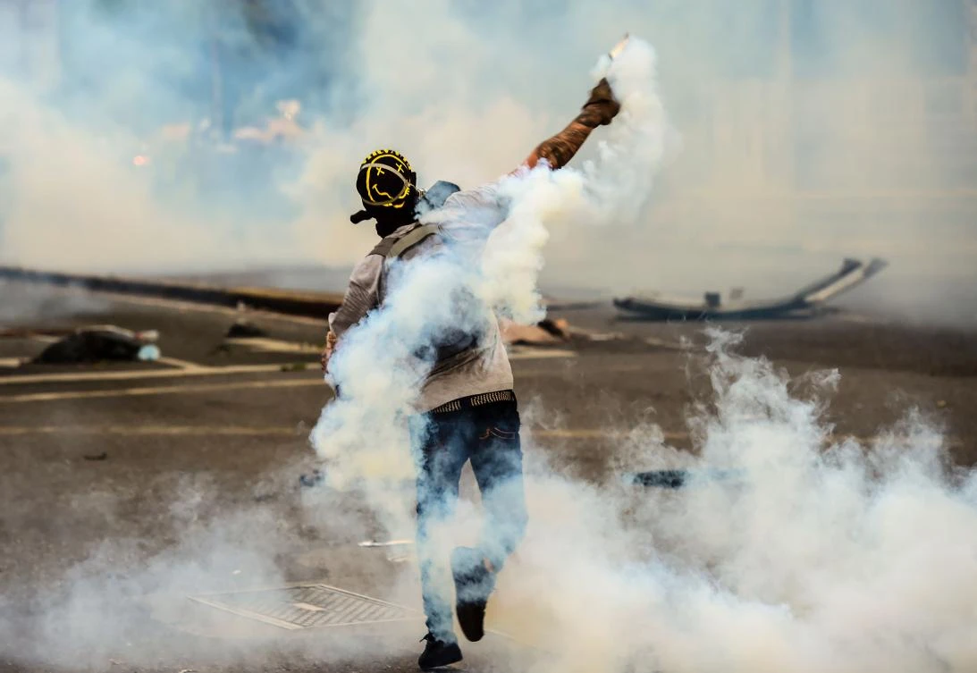 An opposition activist clashes with the police during a protest against Venezuelan President Nicolas Maduro in Caracas, on Tuesday. (AFP)