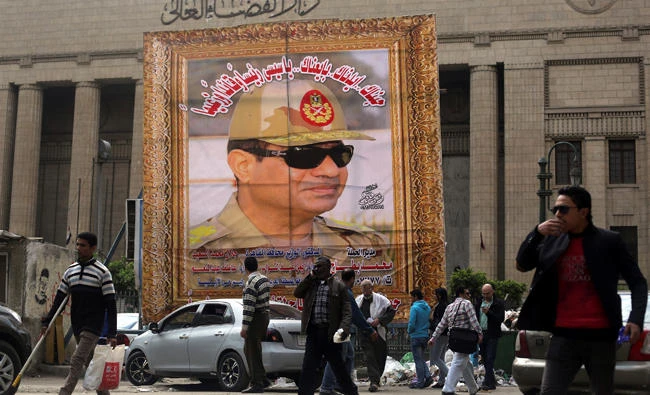 People walk past a banner of Egypt’s President Abdel Fattah El-Sisi in Cairo in this file photo. (Reuters)