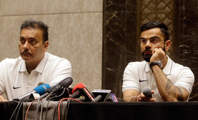 Indian cricket team captain Virat Kohli, right and head coach Ravi Shastri listen to a question during a press conference before leaving for their Sri Lanka tour in Mumbai Wednesday. (AP)
