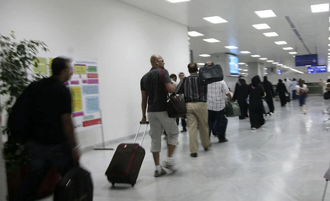 Passengers queue up at the immigration counter at the King Abdulaziz International Airport in Jeddah in this file photo. Saudi Arabian Airlines has lifted the ban on passengers taking large electronic devices aboard aircraft as carry-on.