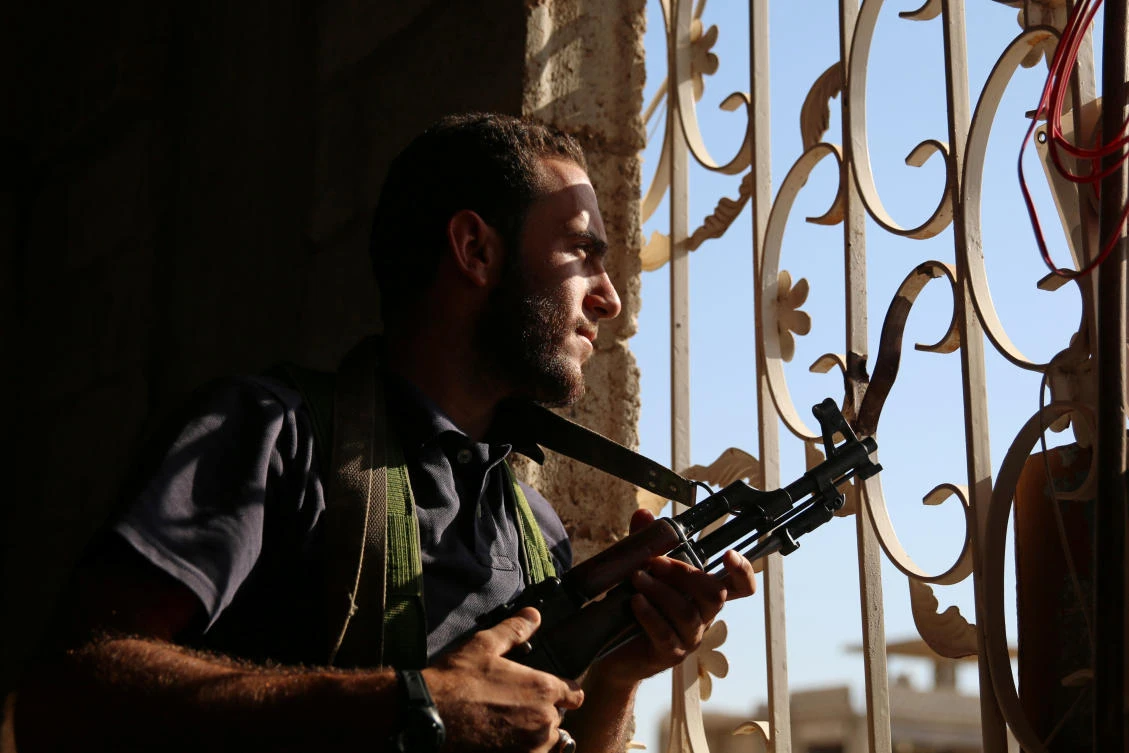 A Free Syrian Army fighter looks out through a window in rebel-held Al-Yadudah village, in Daraa governorate, Syria, on Wednesday. The Trump administration has decided to halt the CIA’s covert program to equip and train certain opposition groups fighting the government of Syrian President Bashar Assad. (REUTERS/Alaa Al-Faqir)