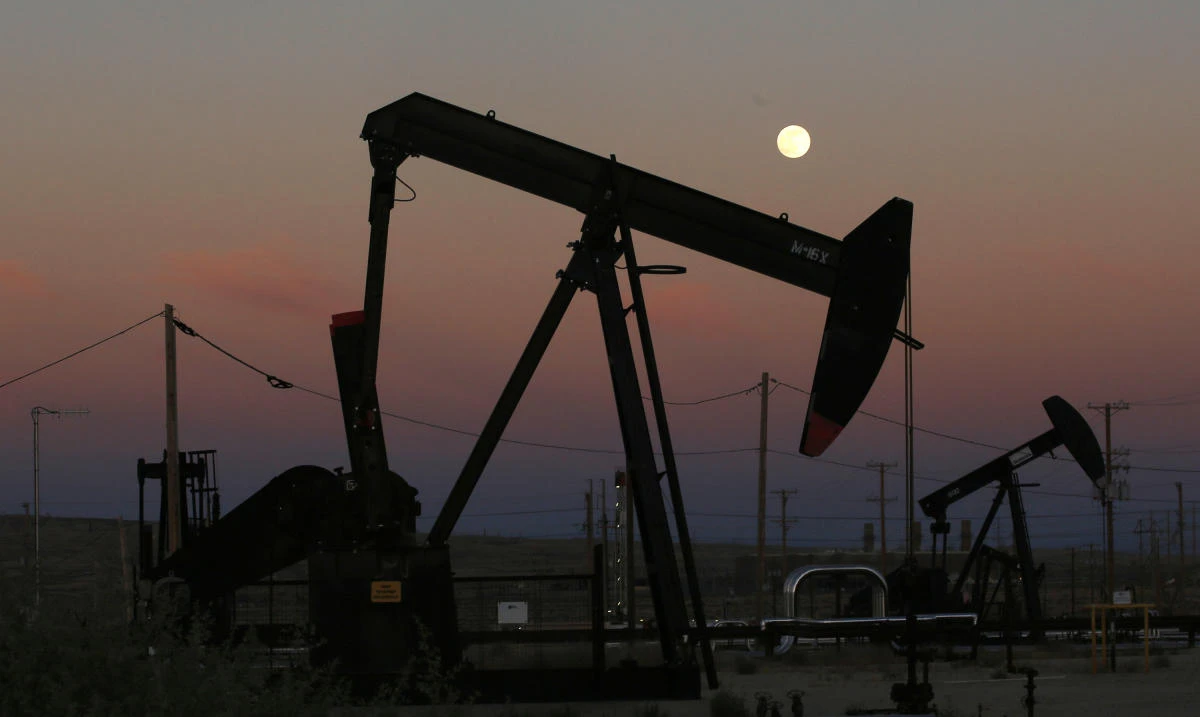 Oil derricks are busy pumping as the moon rises near the La Paloma Generating Station in McKittrick, California, on June 8. (AP Photo)