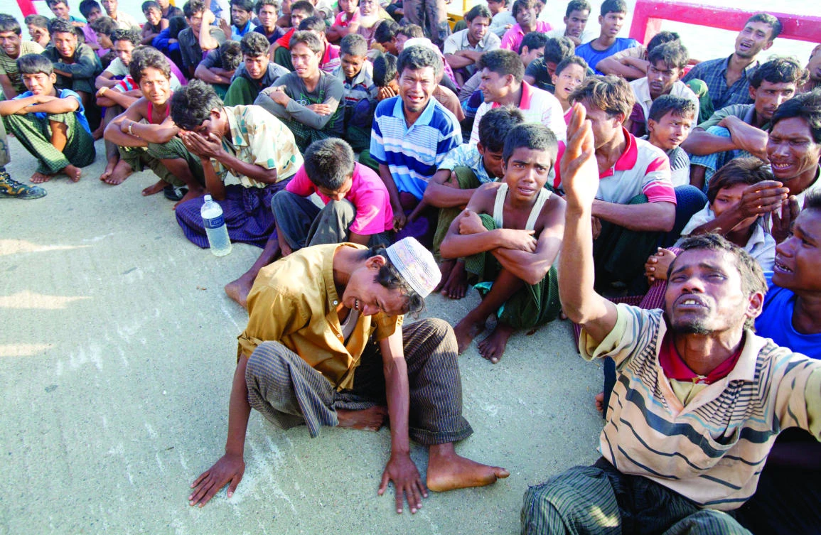 Rohingya Muslim men fleeing from ethnic violence in Myanmar cry as their boat jetty is pushed back to Myanmar in Taknaf, Bangladesh, on Monday. (AP)