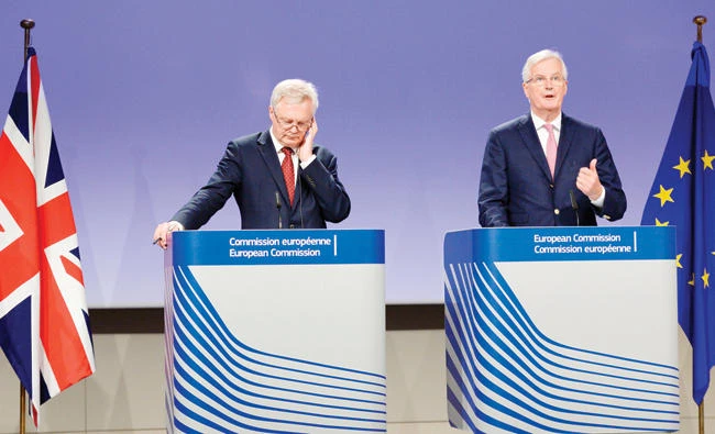 David Davis, left, listens to Michel Barnier as he addresses media representatives during a press conference in Brussels on Thursday. (AFP)