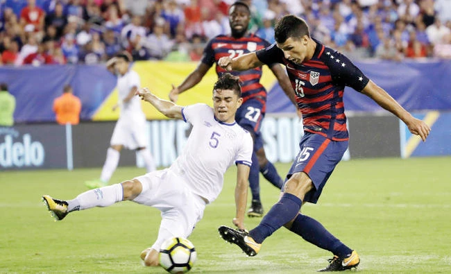 Eric Lichaj (15) of the US kicks a goal against El Salvador's Ivan Mancia during a CONCACAF Gold Cup quarterfinal soccer match in Philadelphia Wednesday. (AP)
