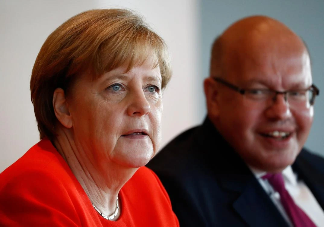 German Chancellor Angela Merkel and German Chief of Staff Peter Altmaier wait for the start of the weekly cabinet meeting on July 12, 2017 at the Chancellery in Berlin. (AFP)