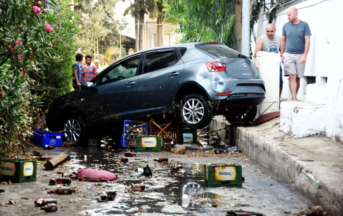 People look at a damaged car following a sea surge caused by an earthquake on July 21, 2017 in Bodrum, southwestern Turkey. Two foreigners died and more than 100 people were injured on the Greek island of Kos when an earthquake shook popular Greek and Turkish holiday destinations in the Aegean Sea. The epicentre of the 6.7 magnitude quake was some 10.3 kilometres (6.4 miles) south of the major Turkish resort of Bodrum, a magnet for holidaymakers in the summer, and 16.2 kilometres east of the island of Kos in Greece, the US Geological Survey said. (AFP)