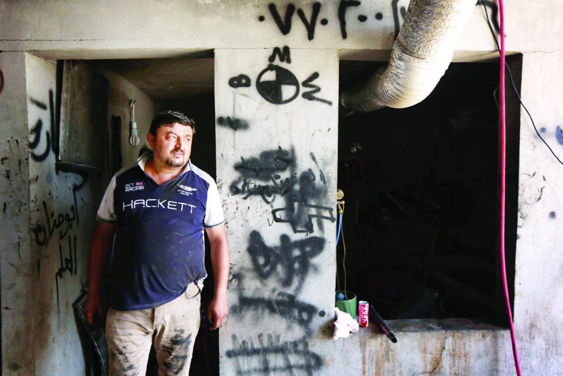 Haitham Behnam, a Christian from Mosul, stands at his workshop in Arbil, Iraq, on Thursday. (AFP)