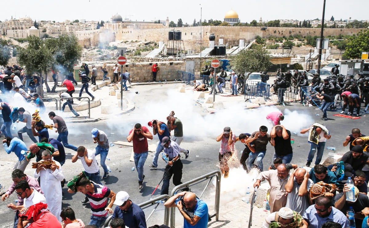 Palestinian worshippers run for cover from teargas fired by Israeli forces outside Jerusalem’s Old City in front
of the Al-Aqsa Mosque compound on Friday. (AFP)