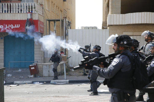 A Palestinian Red Crescent member aids a protester injured during clashes between demonstrators and Israeli security forces at the Qalandiya checkpoint. (AFP)