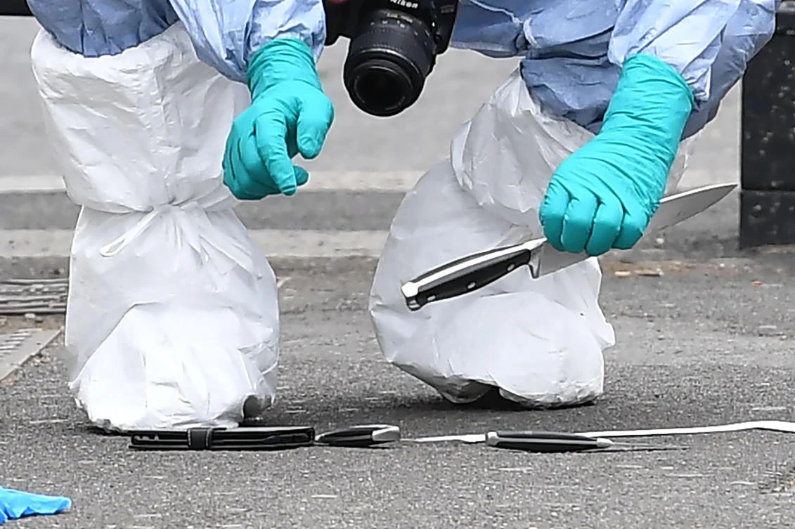 (FILES) This file photo taken on April 27, 2017 shows a British police forensics officer holds a knife as he collects evidence on Whitehall near the Houses of Parliament in central London. Nearly one young person a week has been stabbed to death in London so far this year, leaving British authorities hunting for ways to stop the increasing violence. Twenty-seven people under the age of 25 have been stabbed to death in London since the start of 2017, according to figures from city hall. (AFP)