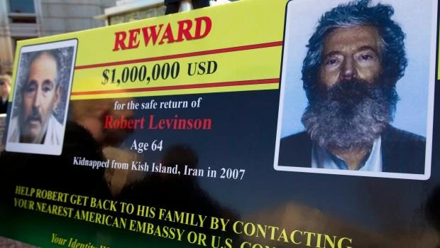 In this March 6, 2012 file photo, an FBI poster showing a composite image of former FBI agent Robert Levinson, right, of how he would look like now after five years in captivity, and an image, left, taken from the video, released by his kidnappers, in Washington during a news conference. (AP)