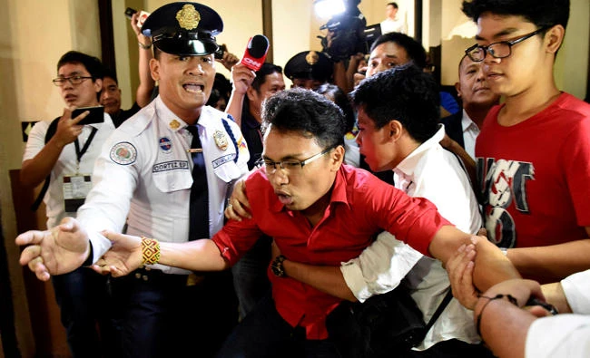 An anti martial law protestor is held by security during the special session on the extension of martial law at the House of Representatives in Quezon City, metro Manila, Philippines on Saturday. (REUTERS)