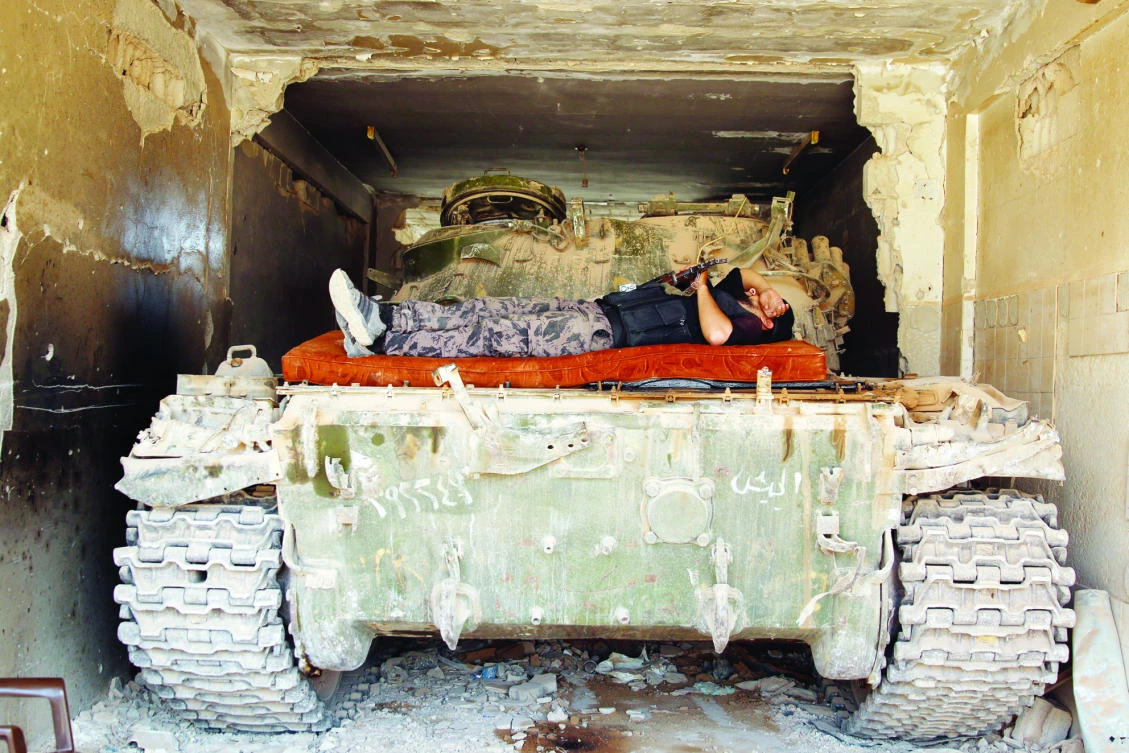 An anti-Assad fighter rests on a tank in in Deraa, Syria, on Friday. (Reuters)