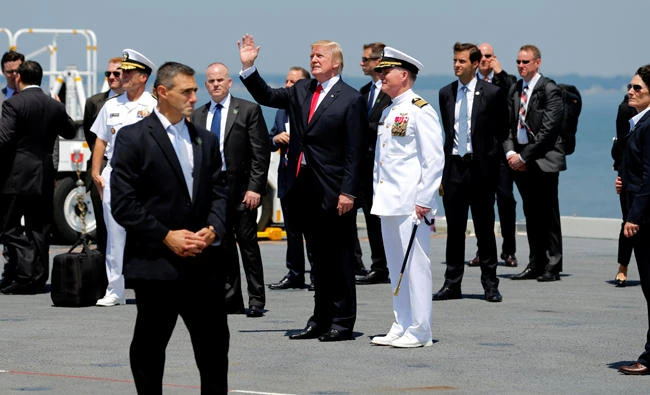 US President Donald Trump (C), flanked by US Navy Captain Richard McCormack (in white), departs after commissioning the aircraft carrier USS Gerald R. Ford at Naval Station Norfolk in Norfolk, Virginia, on Friday. ((REUTERS/Jonathan Ernst)