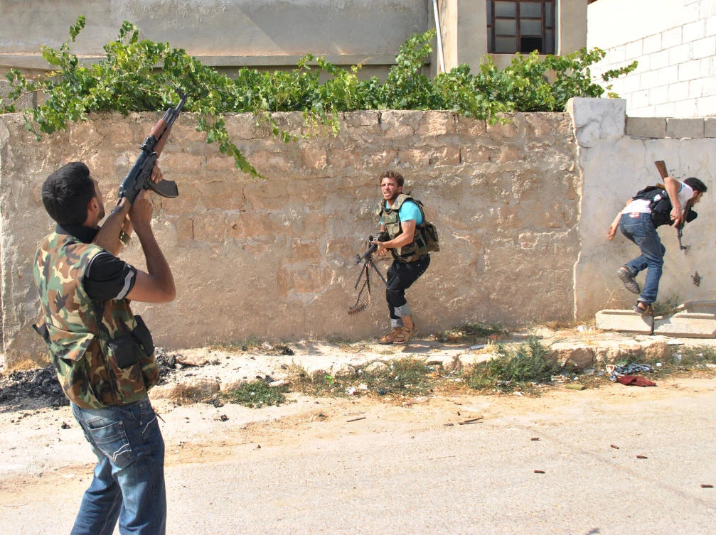 In this picture taken on June 26, 2012, a Syrian rebel fires at a helicopter during a clashes with the Syrian forces troops in Idlib province. (AP)