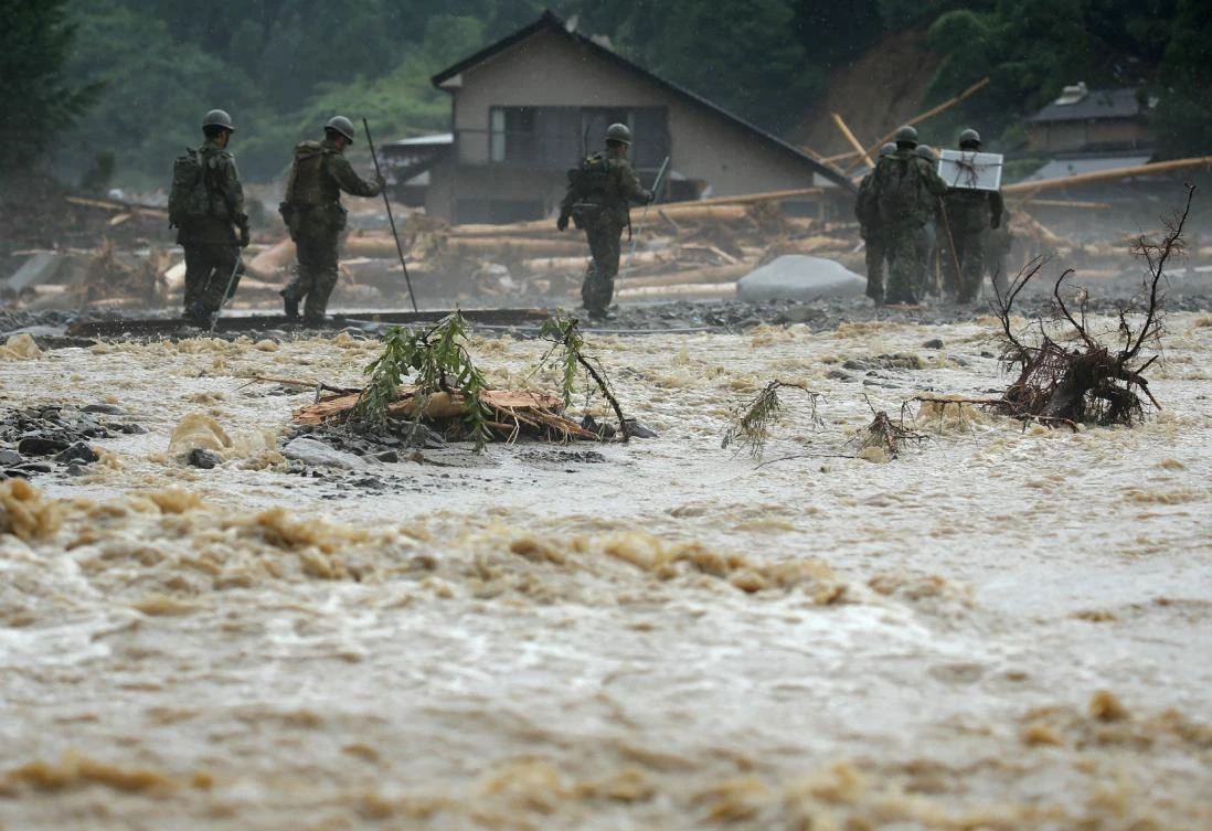 Defense forces soldiers walk beside a river during a search operation for missing poeple in a flooded area in Asakura on July 9, 2017. The death toll from heavy rains and flooding in southern Japan has risen to 15, a government official, as rescuers continued work to evacuate isolated survivors. (AFP)