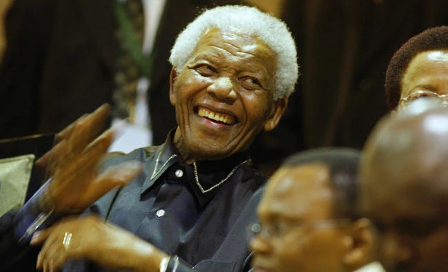 This file photo taken on February 11, 2010, shows former South African president Nelson Mandela (L) with his wife Graca Machel (R) in the parliament gallery in Cape Town. An ambulance carrying Mandela caught fire as it was rushing him to hospital, his doctor revealed in a book published on July 17, 2017. (AFP / Pool / Schalk Van Zuydam)