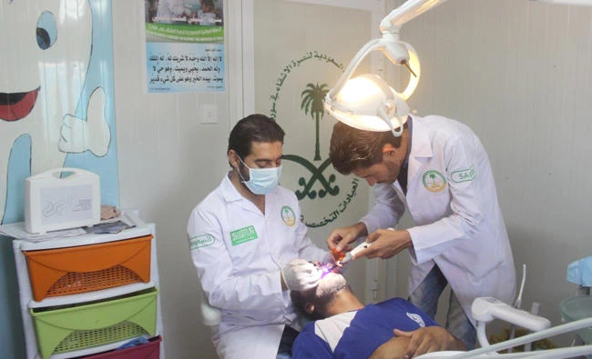 A Syrian man is treated by dentists at a medical center run by the Specialized Saudi Clinics at Zaatari camp in Jordan. (SPA)