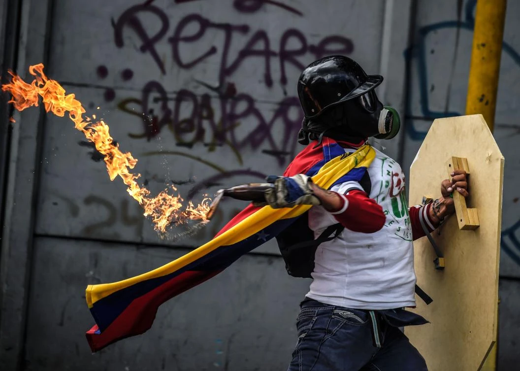 An opposition activist clashes with the police during a march towards the Supreme Court of Justice (TSJ) in an offensive against President Maduro and his call for Constituent Assembly in Caracas on July 22, 2017. The Legislative power, controlled by the opposition, appointed Friday a parallel supreme court in a public session claiming the TSJ judges had been illegally appointed by the parliament’s former pro-government majority. (AFP)