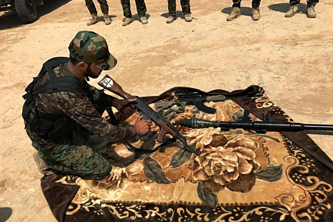 In this Tuesday, July 18, 2017, photo, a Shiite volunteer fighter from the Imam Ali Brigade, an armed faction with the Iraqi Popular Mobilization Forces, trains in a camp in Najaf, 100 miles (160 kilometers) south of Baghdad, Iraq. Iraq’s political, religious and military leaders are debating the future of the country’s powerful Shiite militias after defeating the Islamic State group in Mosul. (AP)