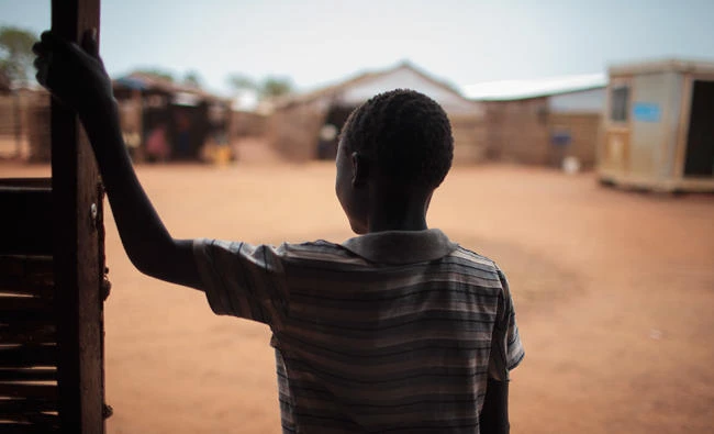 In this photo, thirteen-year-old boy Batista, who five months ago was drugged and raped in the middle of the night, stands in the doorway of a psychosocial support clinic in a camp for the internally-displaced in Wau, South Sudan. (AP Photo/Bruno Bierrenbach Feder)