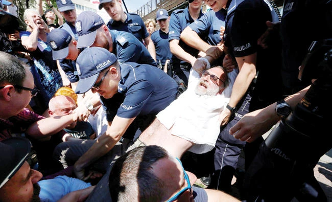 Police officers struggle with anti-government protesters in Warsaw, Poland, on Monday. (Reuters)