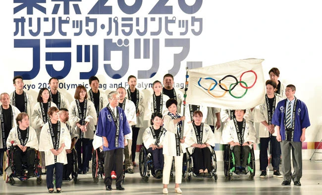 Tokyo governor Yuriko Koike waves the Olympic flag during a ceremony marking three years to go before the start of the Tokyo 2020 Olympic Games at the Tokyo Metropolitan Assembly Building
on Monday. (AFP)