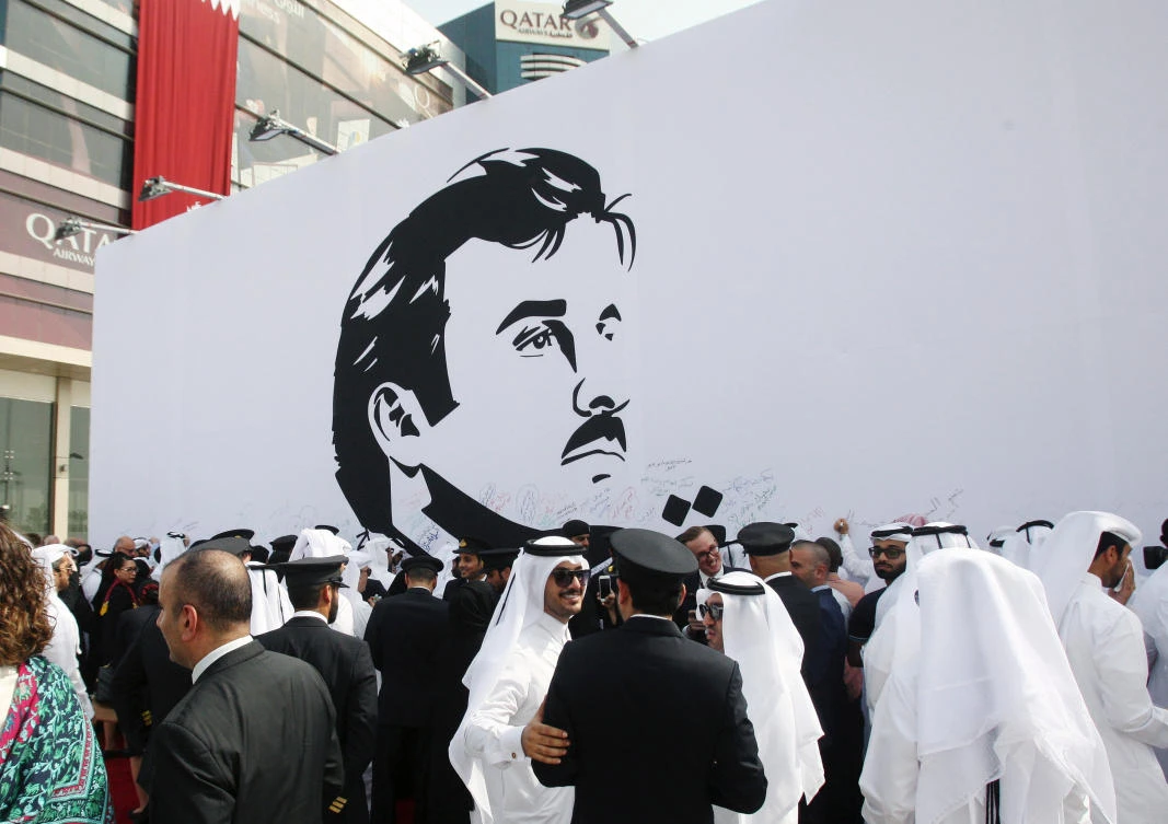 People gather near an artwork depicting Qatar's Emir Sheikh Tamim Bin Hamad Al-Thani after it was unveiled by Qatar Airways in Doha, Qatar. (REUTERS/Naseem Zeitoon)